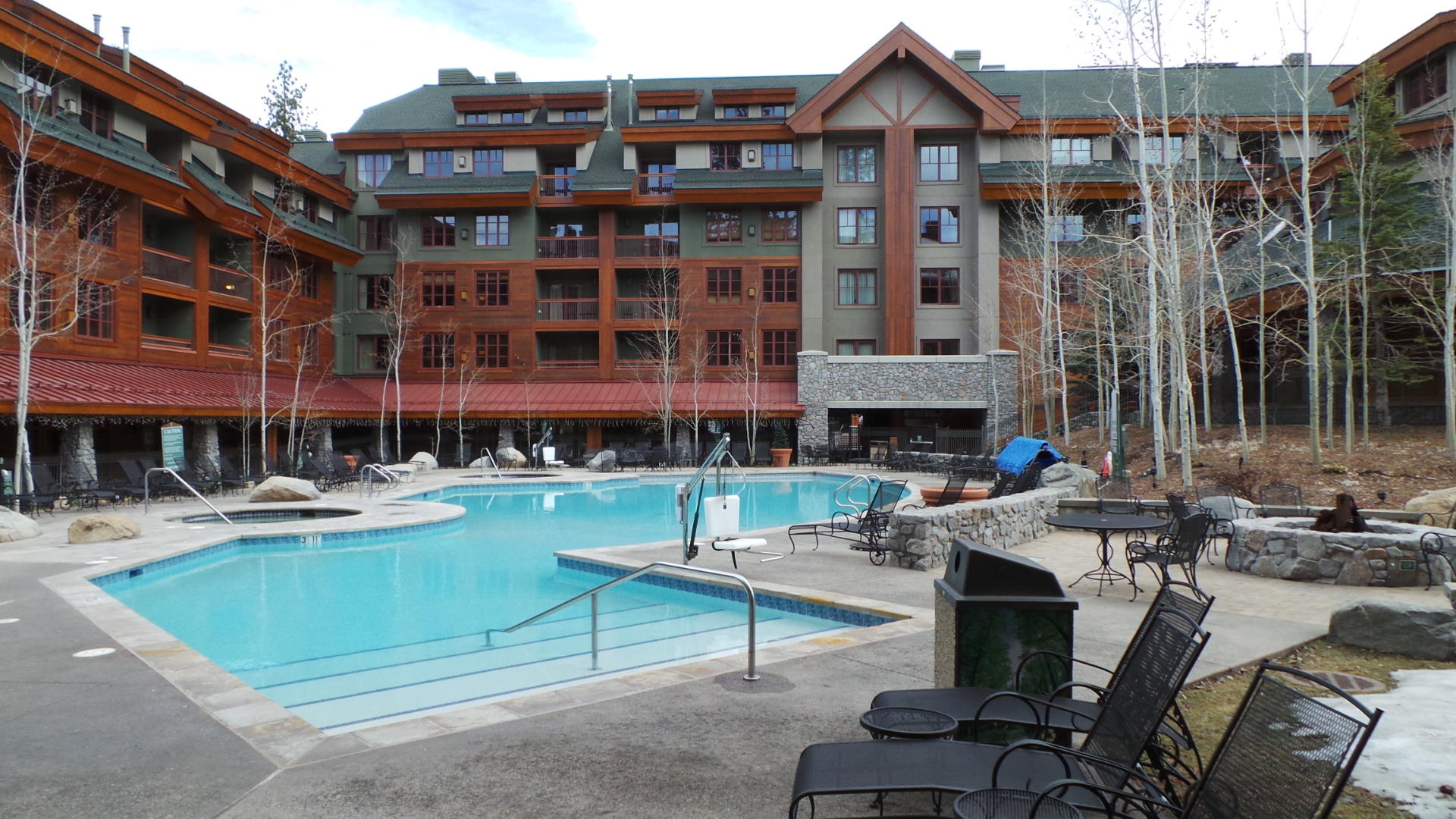 Resort-style heated pool with alpine lodge views and relaxing lounge areas
