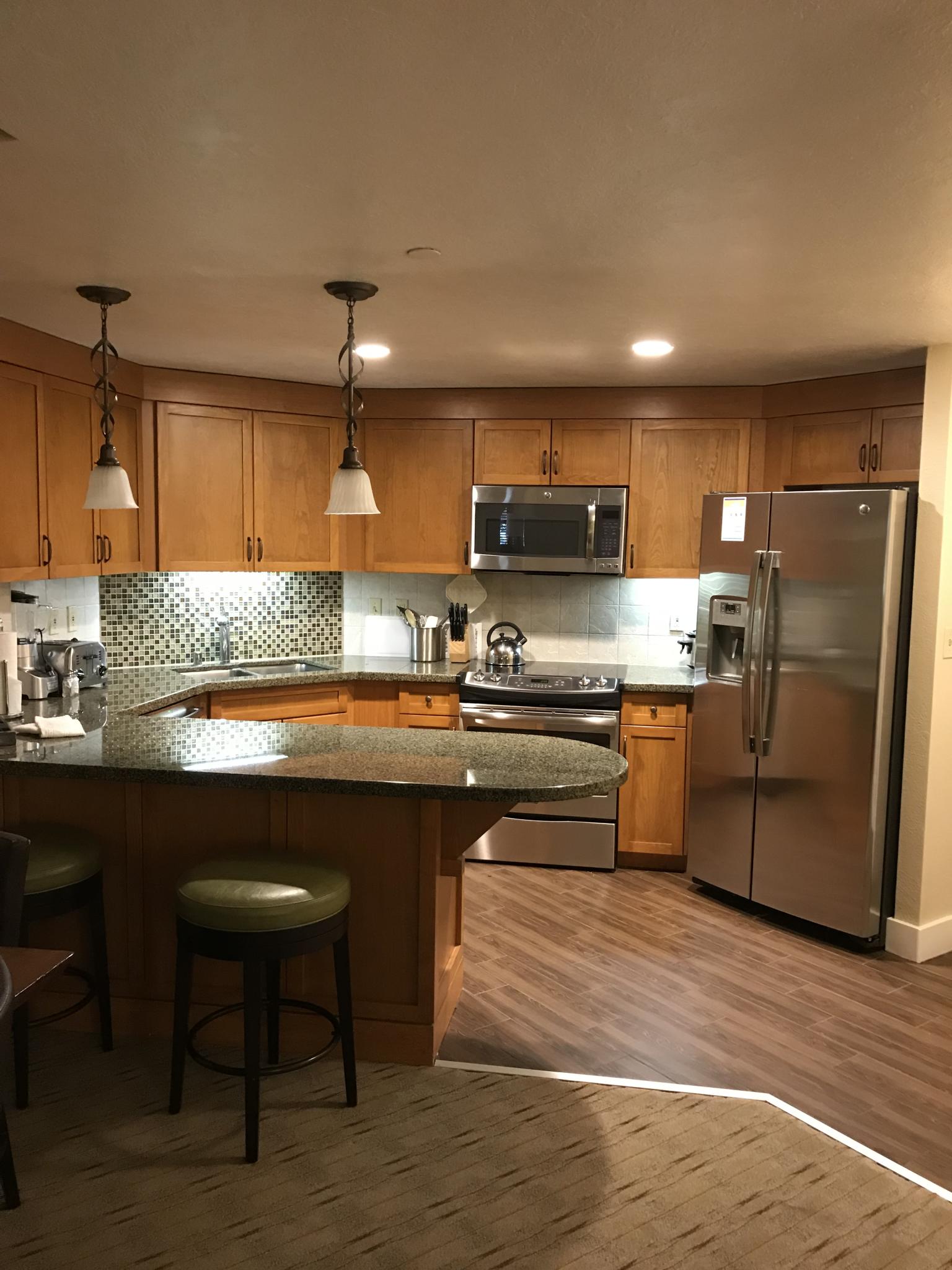 Spacious kitchen with breakfast bar, stainless appliances, and warm finishes
