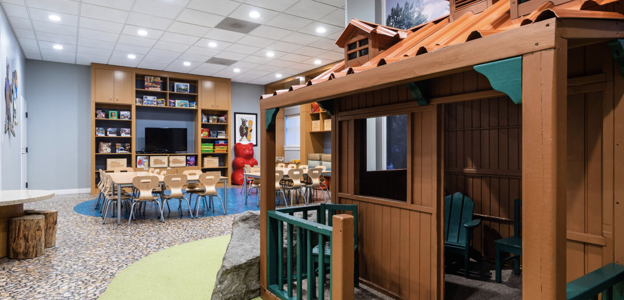 Fun-filled indoor kids’ playroom with games, books, and a charming playhouse