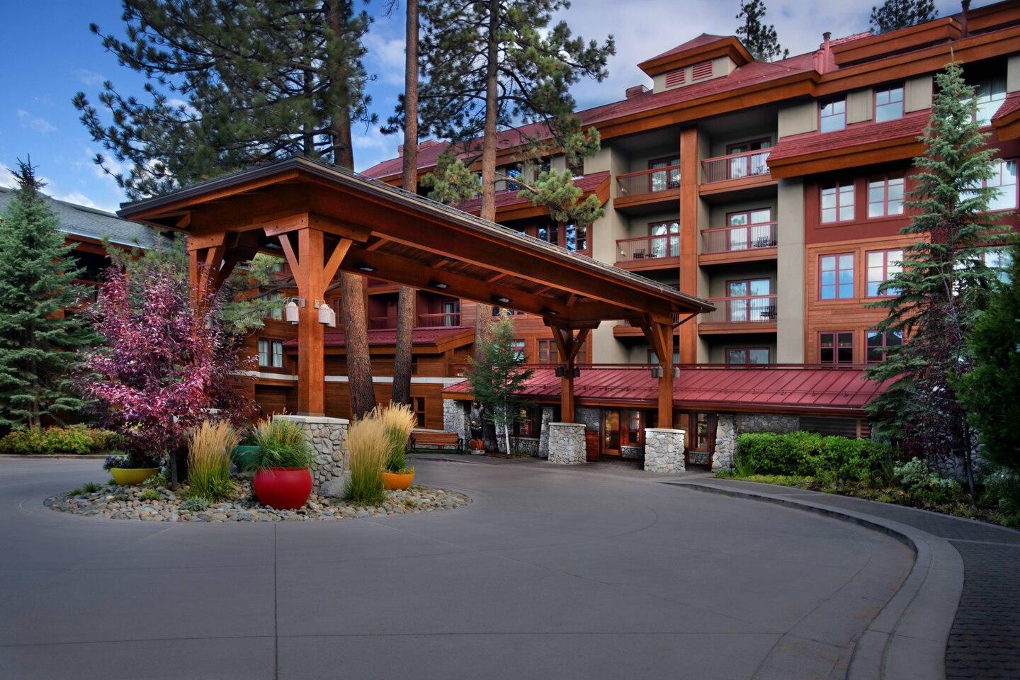 Grand timber lodge entrance with covered drop-off and alpine charm