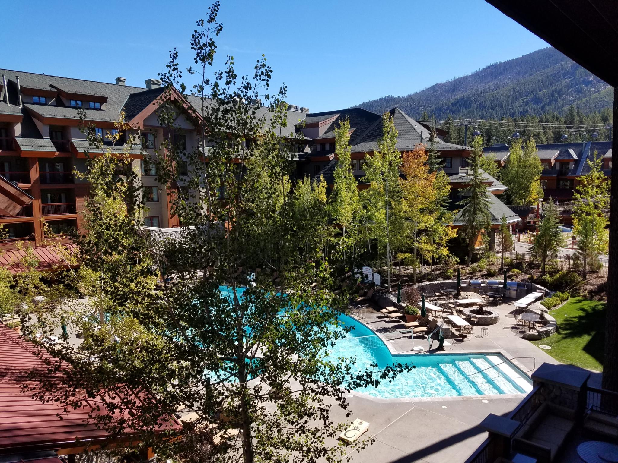Resort-style pool, fire pit, and mountain views in a scenic alpine setting
