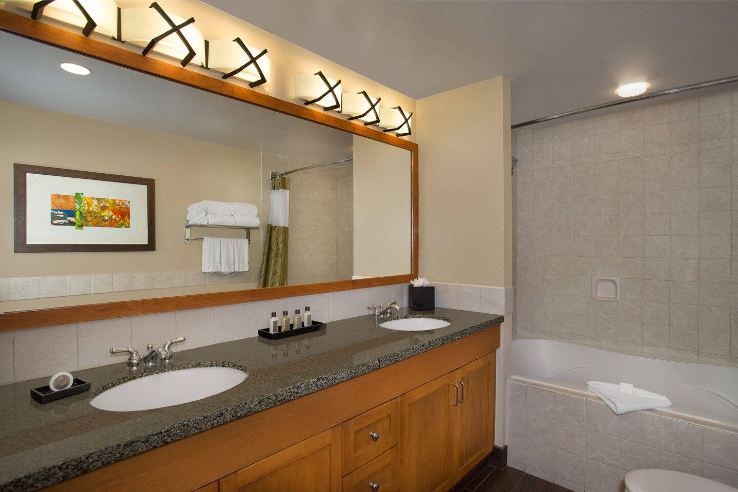 Spacious double-vanity bathroom with granite counters and tub/shower