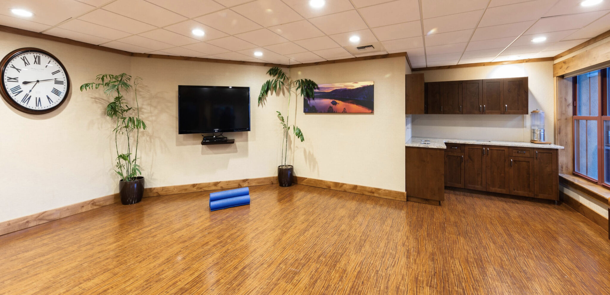 Spacious lounge with TV, kitchenette, and warm wood accents