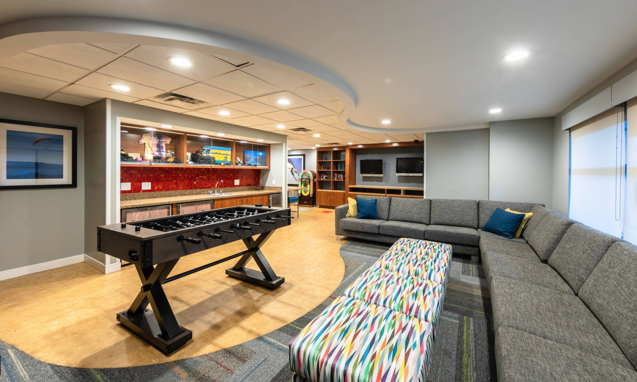 Spacious game lounge with foosball, TVs, and oversized sectional seating