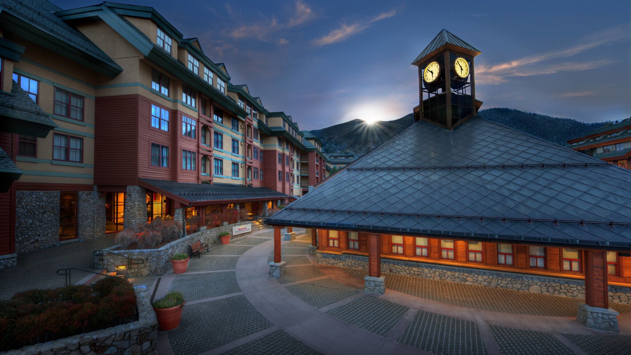 Grand mountain resort entrance with clock tower and scenic alpine views
