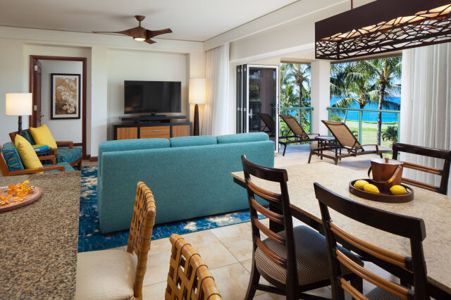 Bright tropical living space with balcony lounge chairs and ocean views