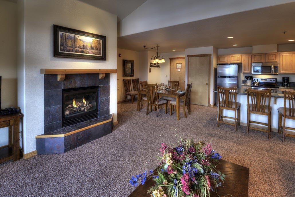 Cozy open living space with fireplace, dining area, and breakfast bar