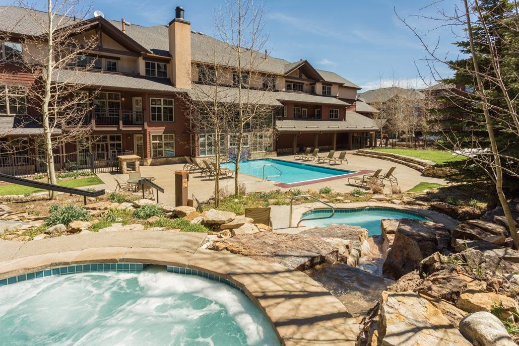 Resort-style courtyard with heated pool, hot tubs, and alpine lodge charm