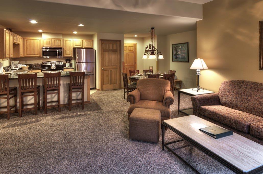 Cozy open living space with full kitchen, bar seating, and dining area