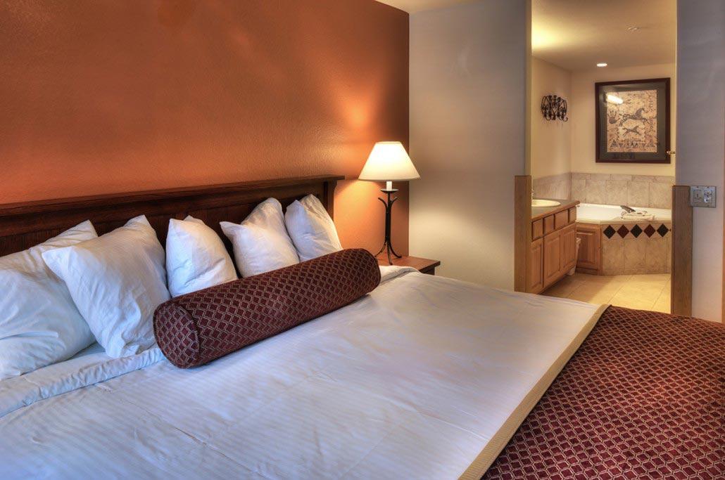 Cozy king bedroom with warm lighting and en suite bath