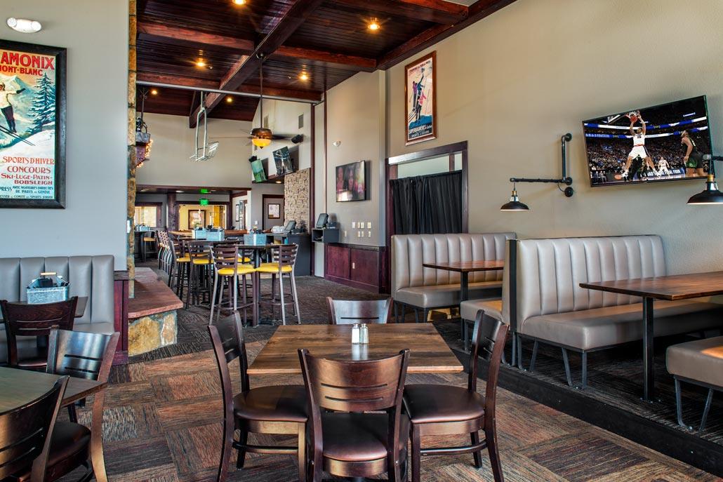 Warm, lodge-style lounge with booth seating, TVs, and inviting gathering space