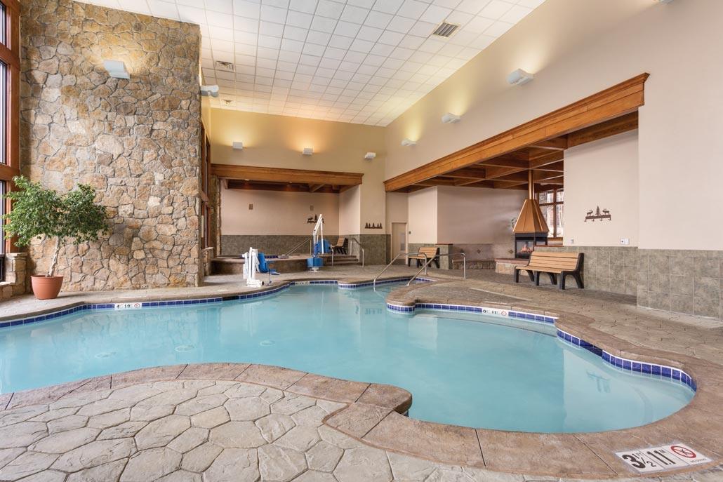 Spacious indoor pool with stone accents and cozy lodge-style ambiance