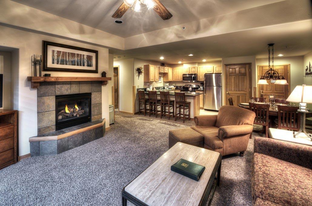 Cozy open living area with fireplace, full kitchen, and dining space