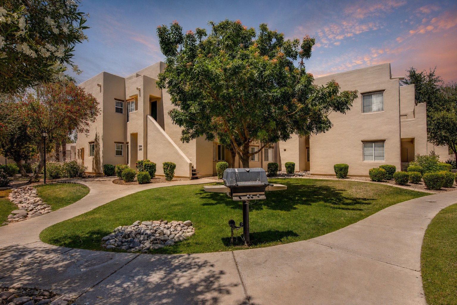 Charming courtyard setting with lush landscaping and outdoor grill