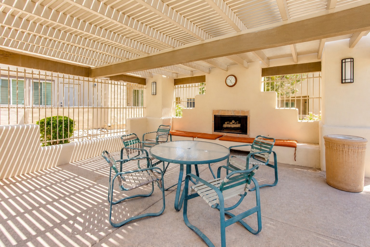 Covered patio with fireplace, dining table, and shaded lounge seating