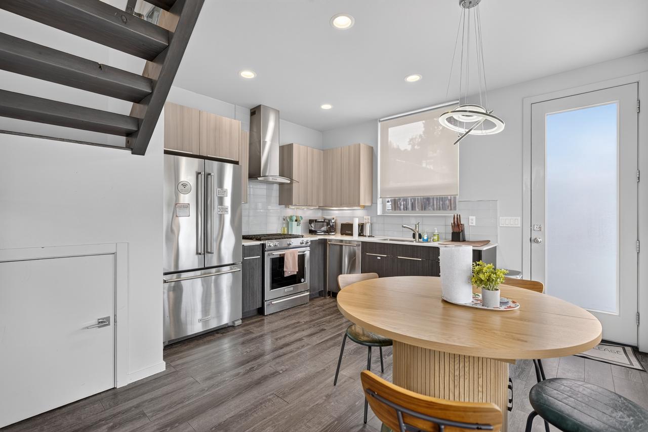 Bright modern kitchen with stainless appliances and stylish dining area