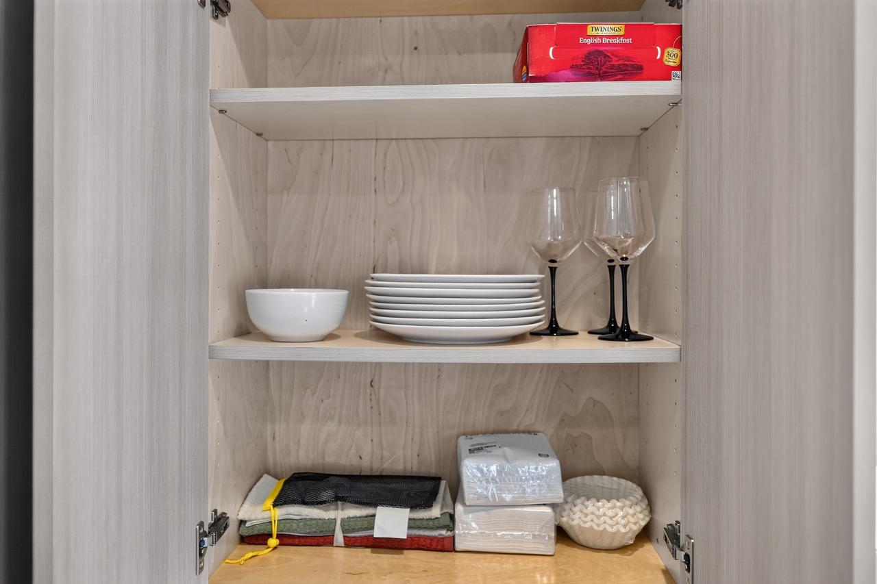 Well-stocked kitchen cabinet with dining essentials and tea