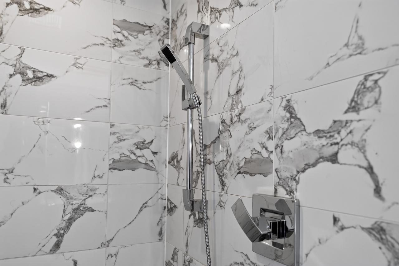 Modern marble-tile shower with sleek chrome fixtures