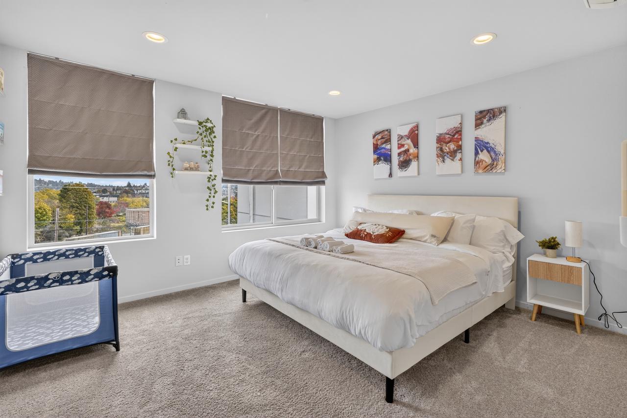 Bright, spacious bedroom with large windows and family-friendly crib