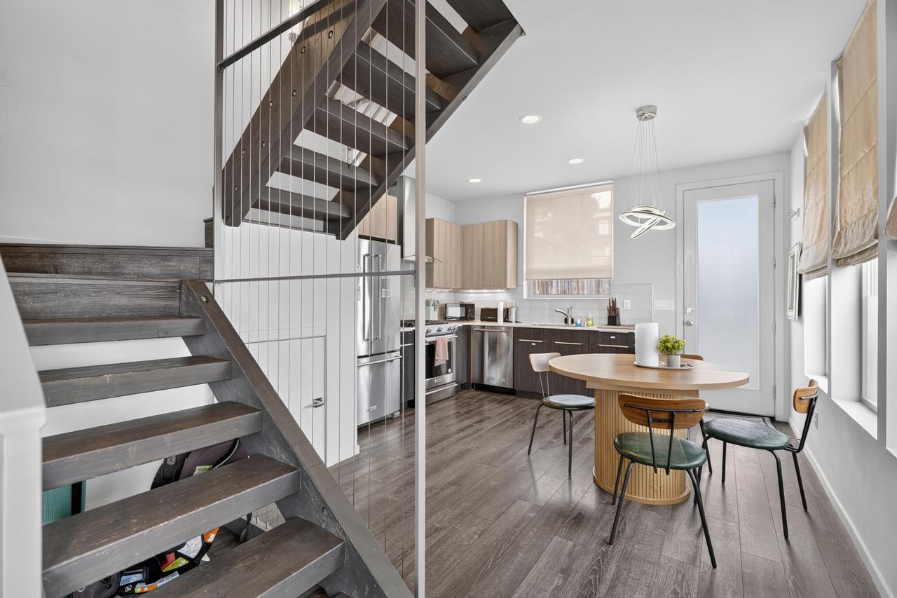 Bright modern kitchen and dining area with stylish open staircase