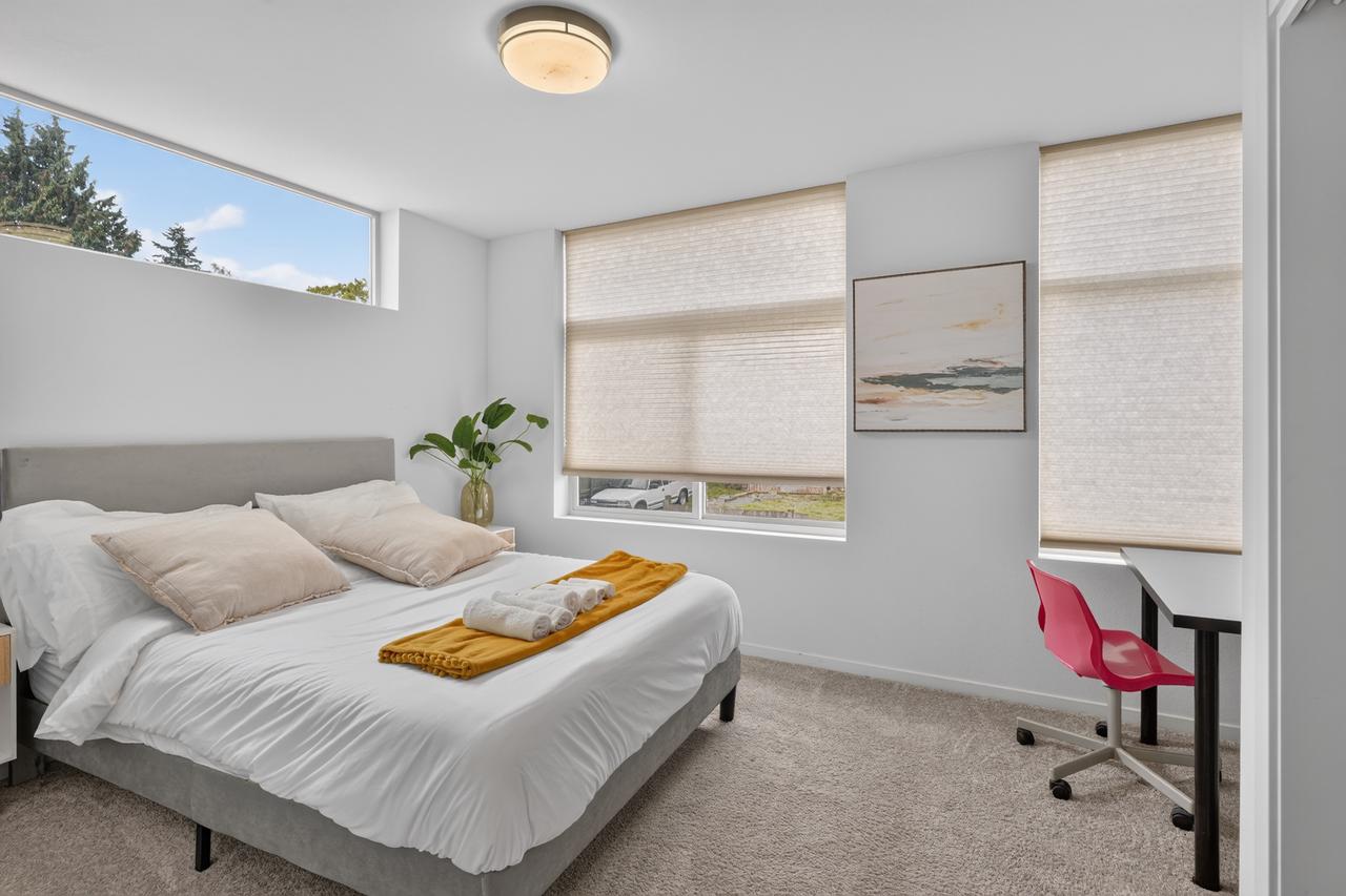 Bright, cozy bedroom with workspace and plenty of natural light