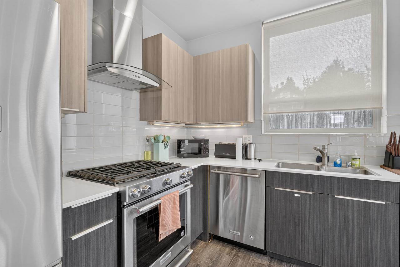 Bright modern kitchen with gas range, dishwasher, and natural light