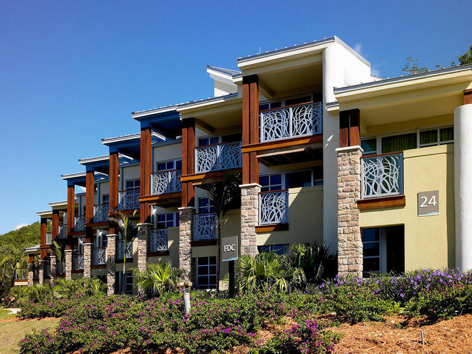 Elegant resort-style building with private balconies and lush tropical landscaping