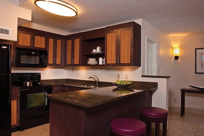 Modern kitchen with granite island, bar seating, and warm designer finishes