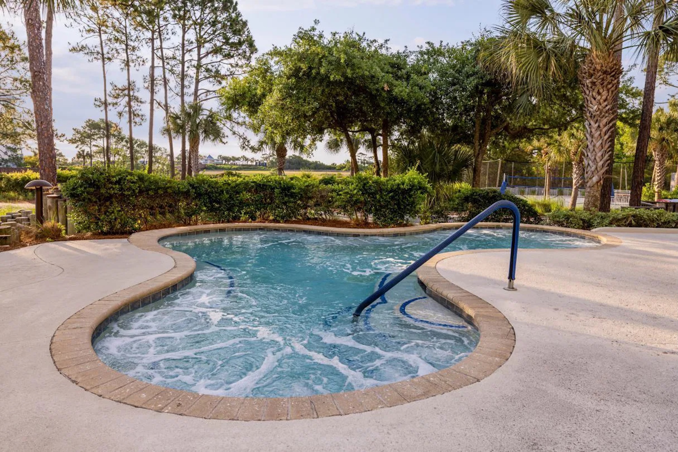 Relaxing resort-style hot tub surrounded by palms and lush greenery