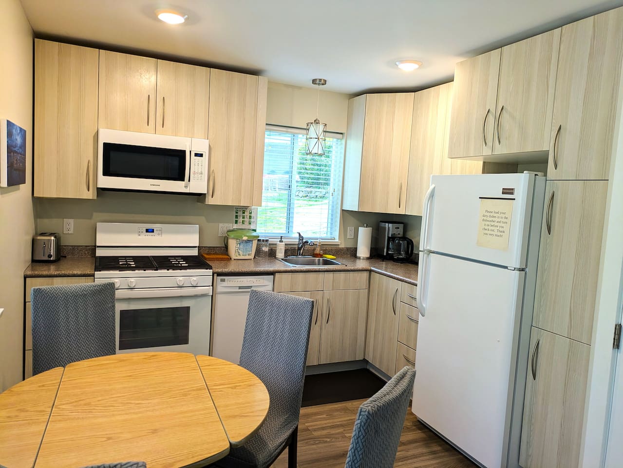 The kitchen includes a gas stove, a microwave, a dishwasher, and a fridge.