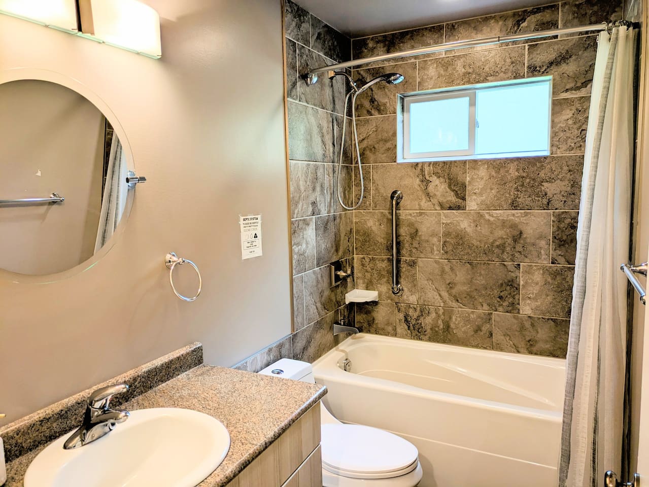 The bathtub shower includes a grab bar, an anti-slip bath mat, and a deep soaking tub.