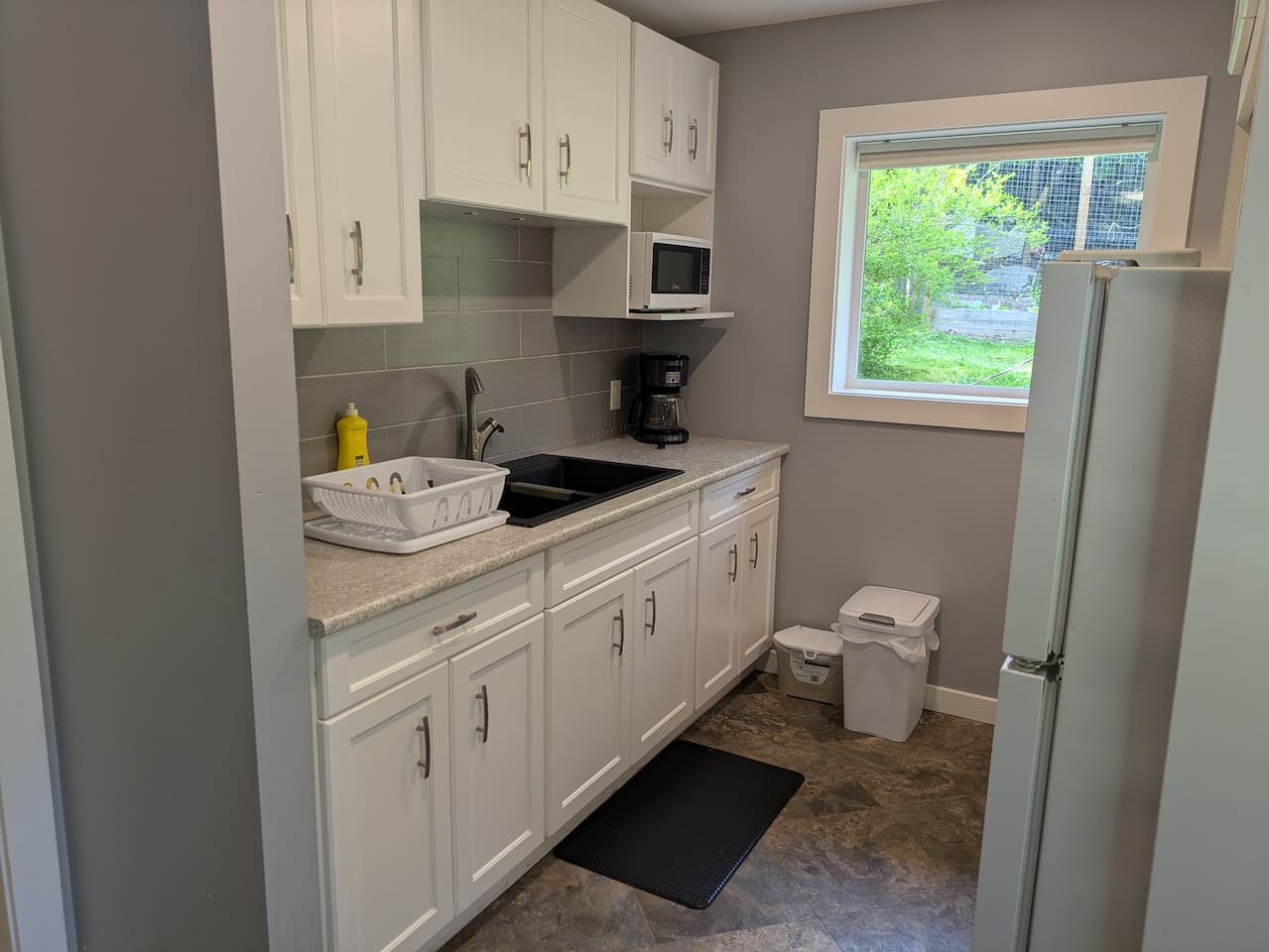 The kitchen features a large window to let in lots of natural light.