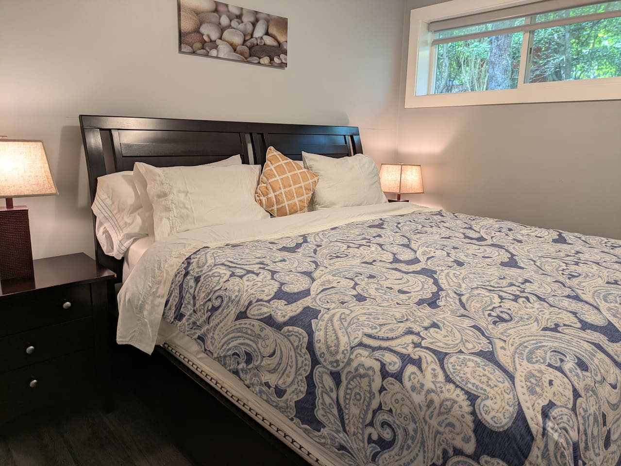 Bright and spacious bedroom featuring a comfortable king-size bed. To the side, a large closet provides ample storage space including a change table.