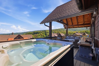 From the spa jets to the built-in grill, this show-stopping covered deck is an entertainment hub of its own — panoramic valley views stretch beneath market lights and a cathedral-style roofline.