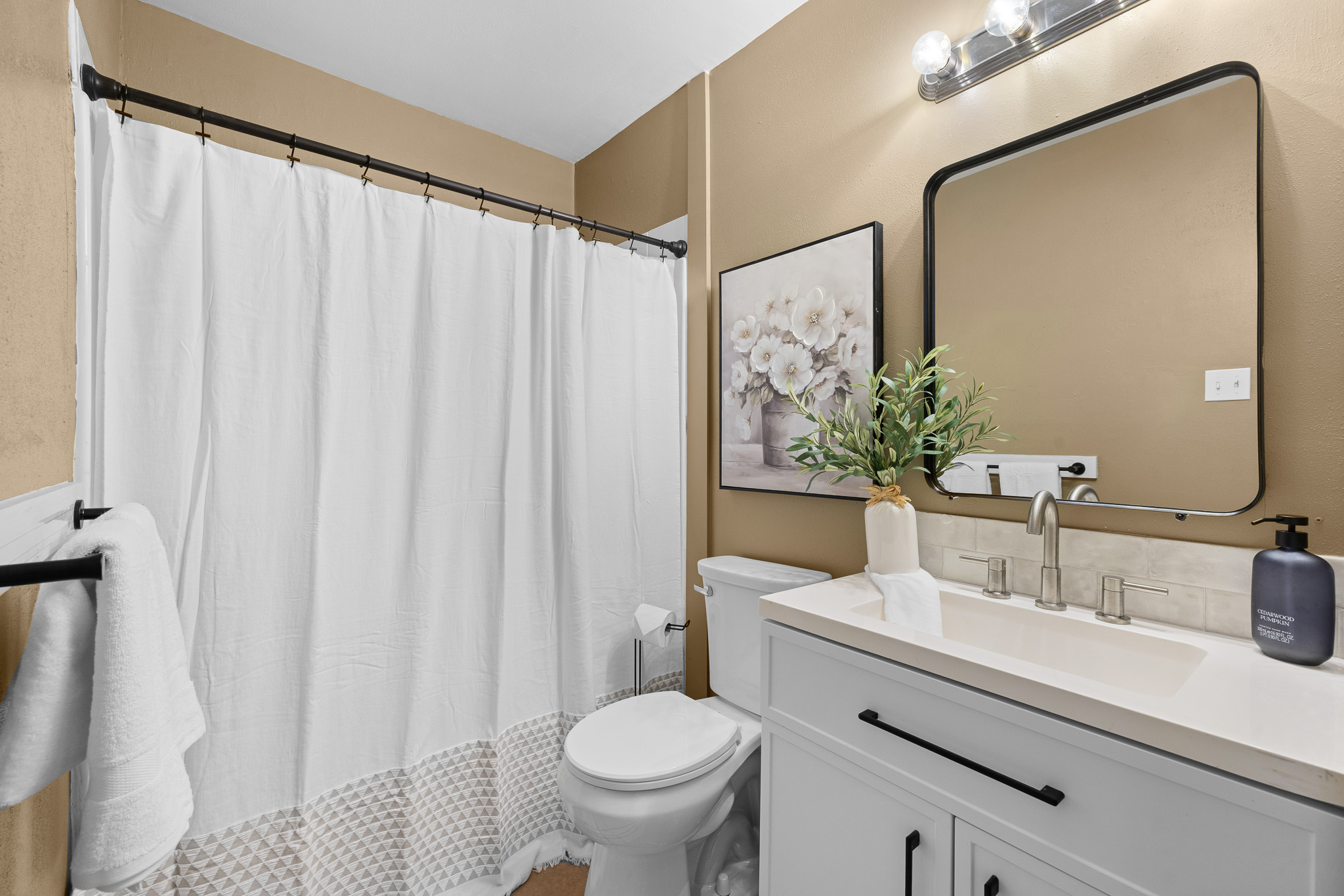 Bright modern bathroom with sleek vanity, large mirror, and fresh finishes
