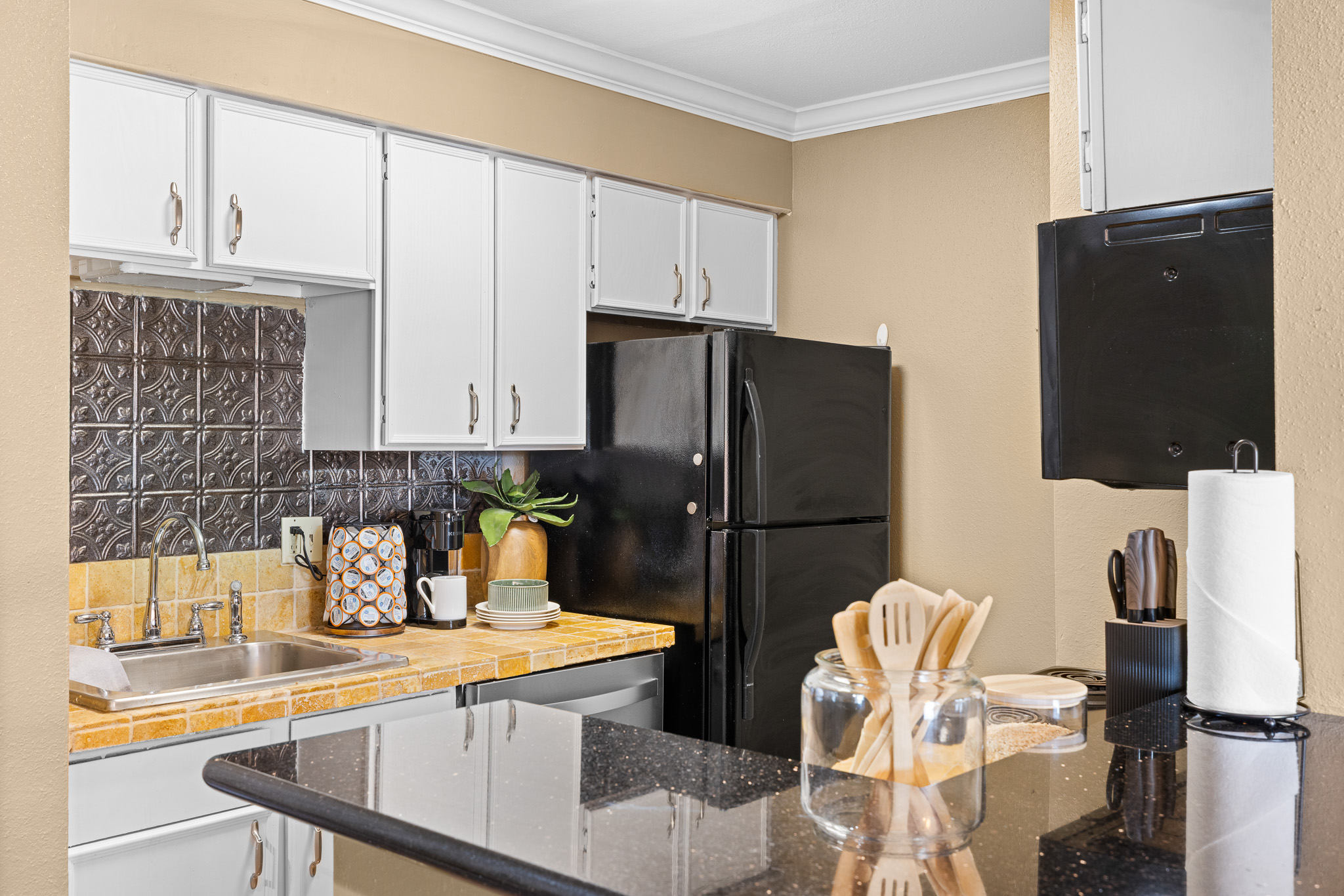 Stylish kitchen with black granite counters and convenient prep space