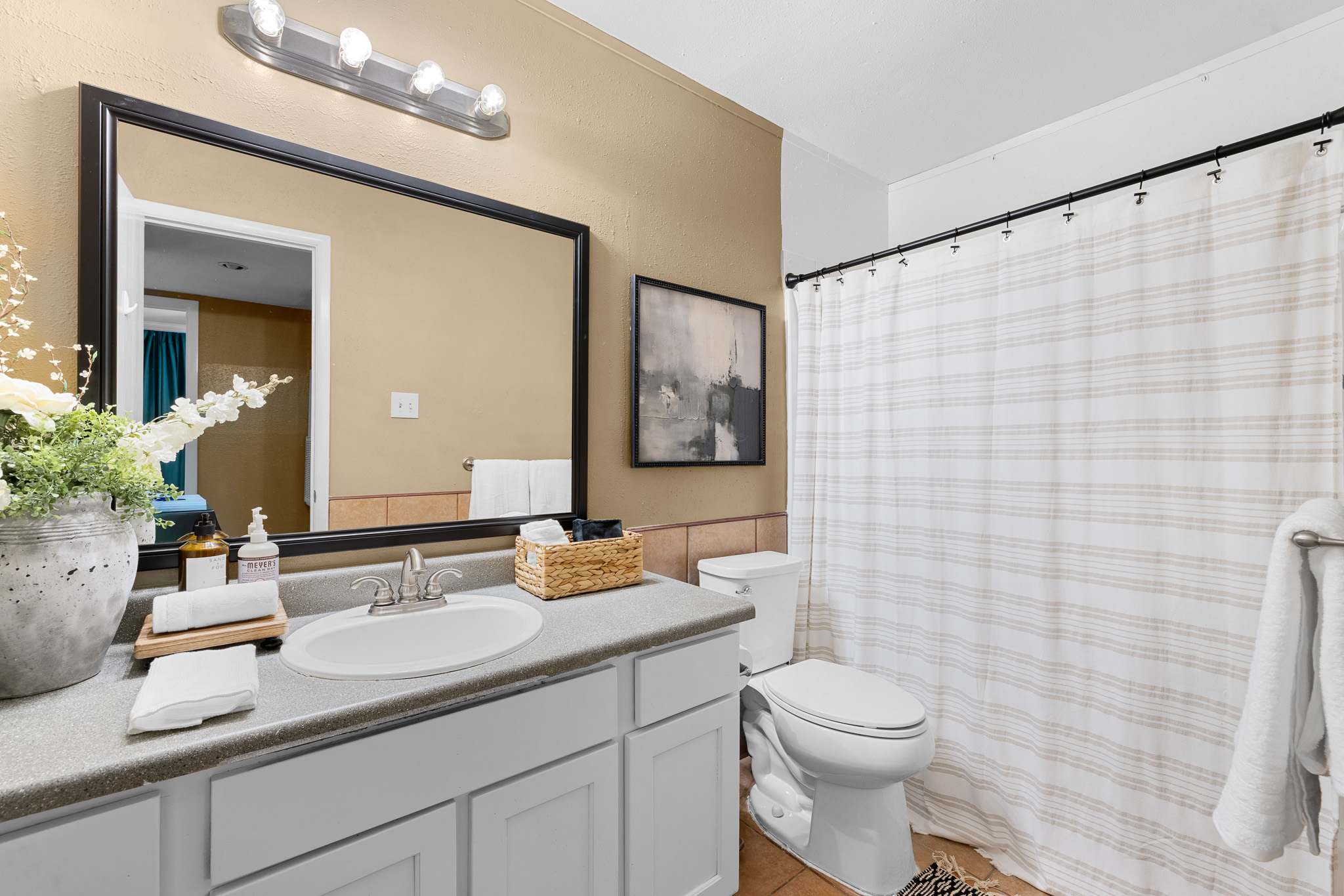 Bright full bathroom with spacious vanity and clean, modern styling