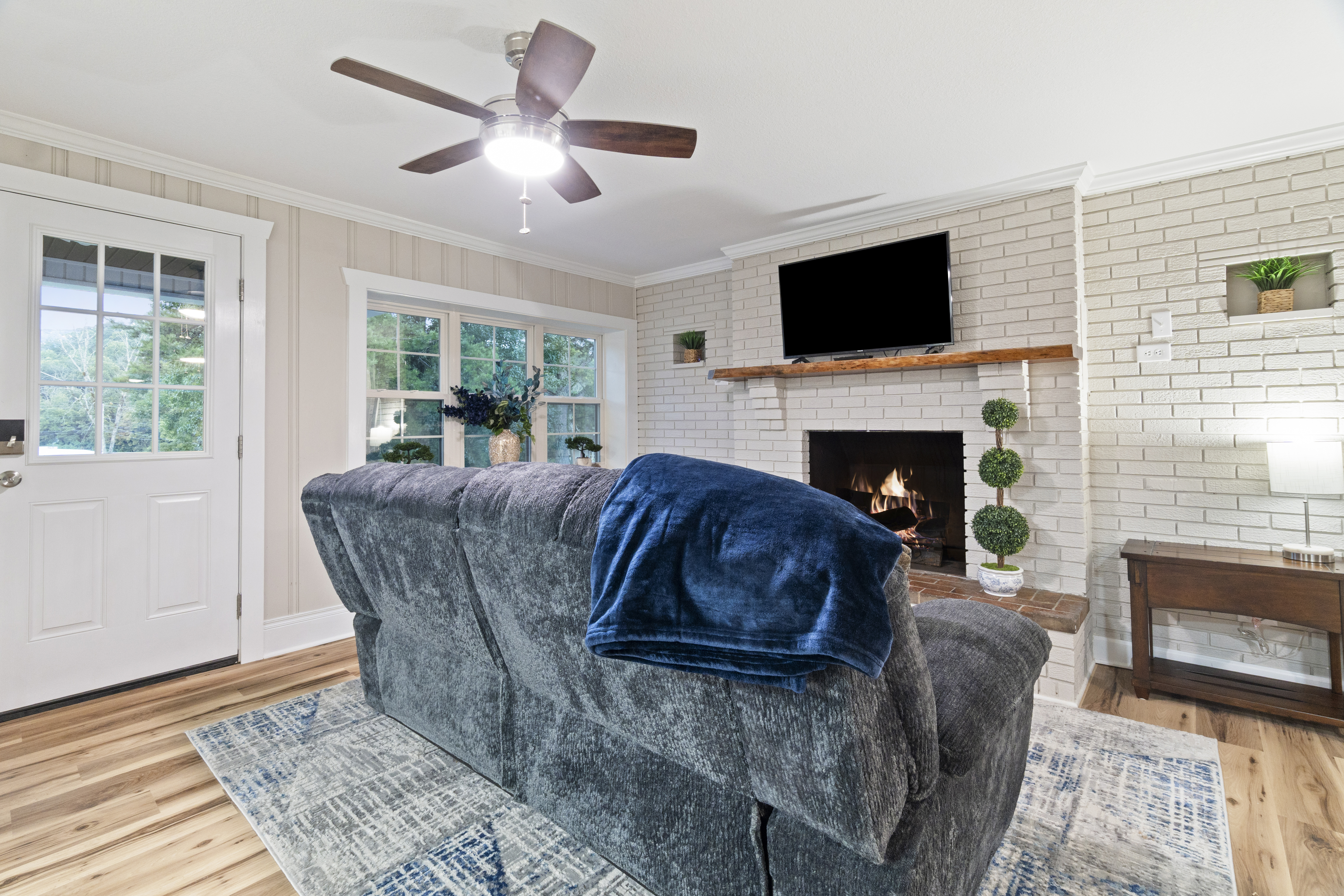 Cozy living room with fireplace, TV, and bright natural light