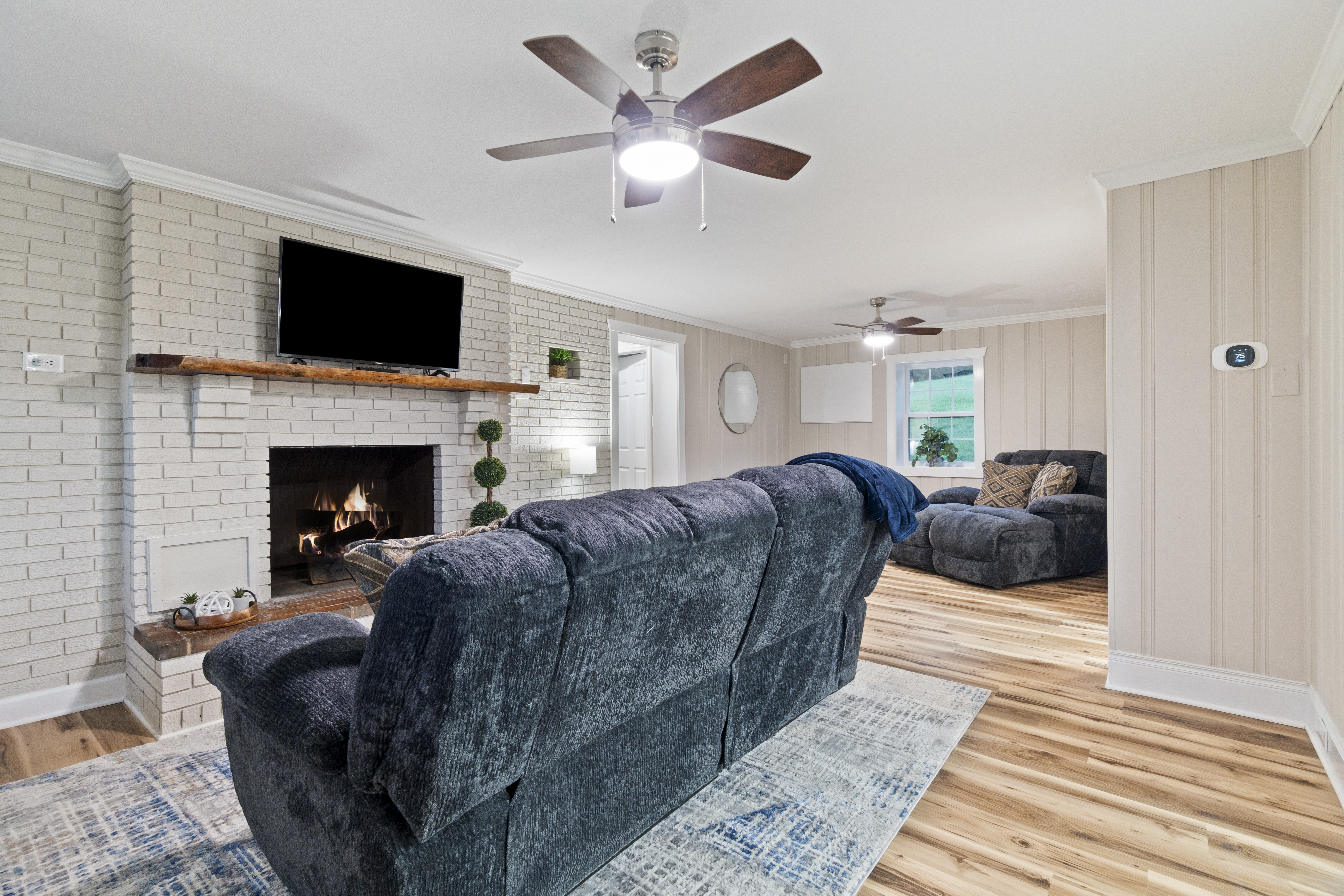 Cozy living room with fireplace, TV, and plush reclining seating