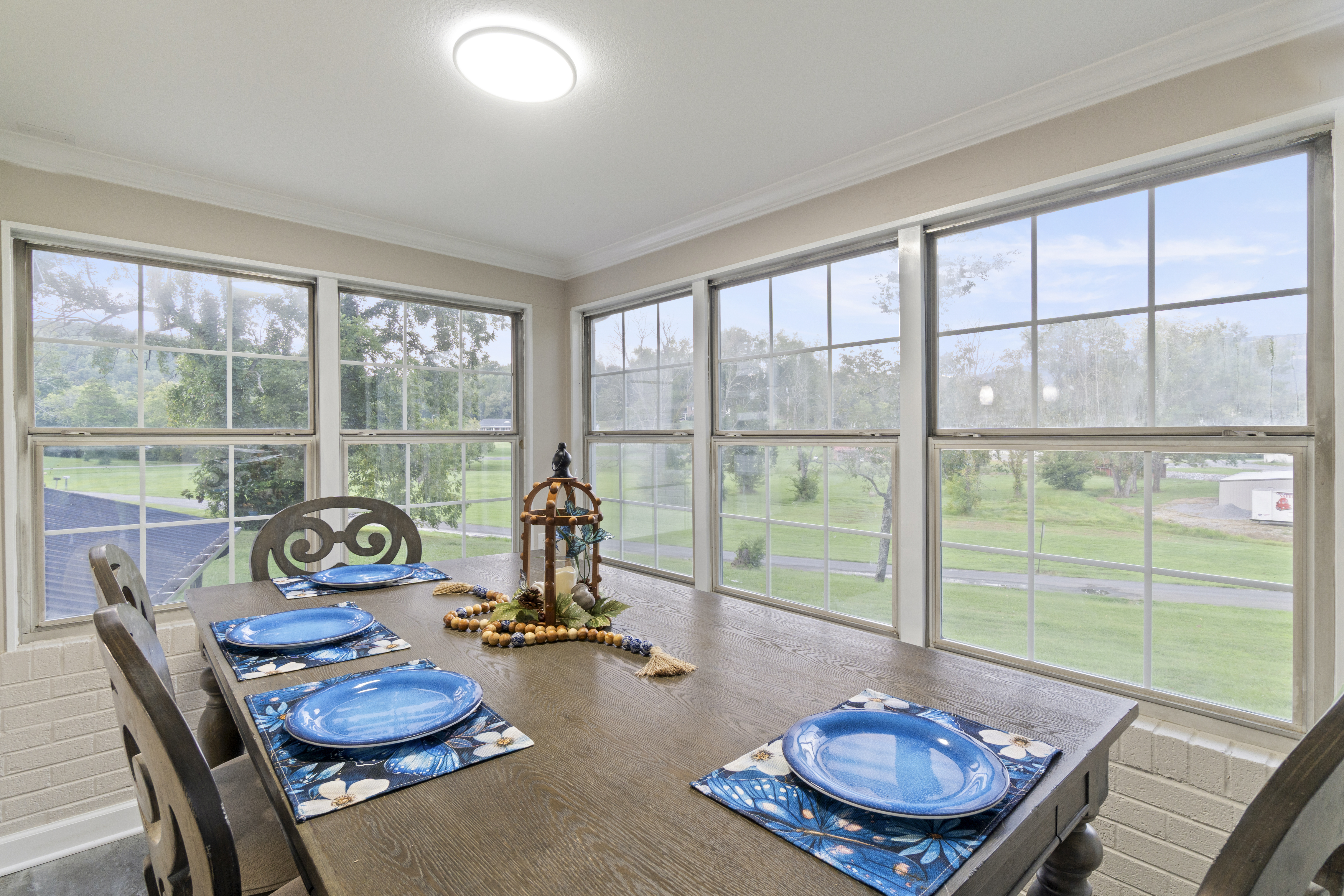 Bright dining nook with panoramic windows and peaceful green views