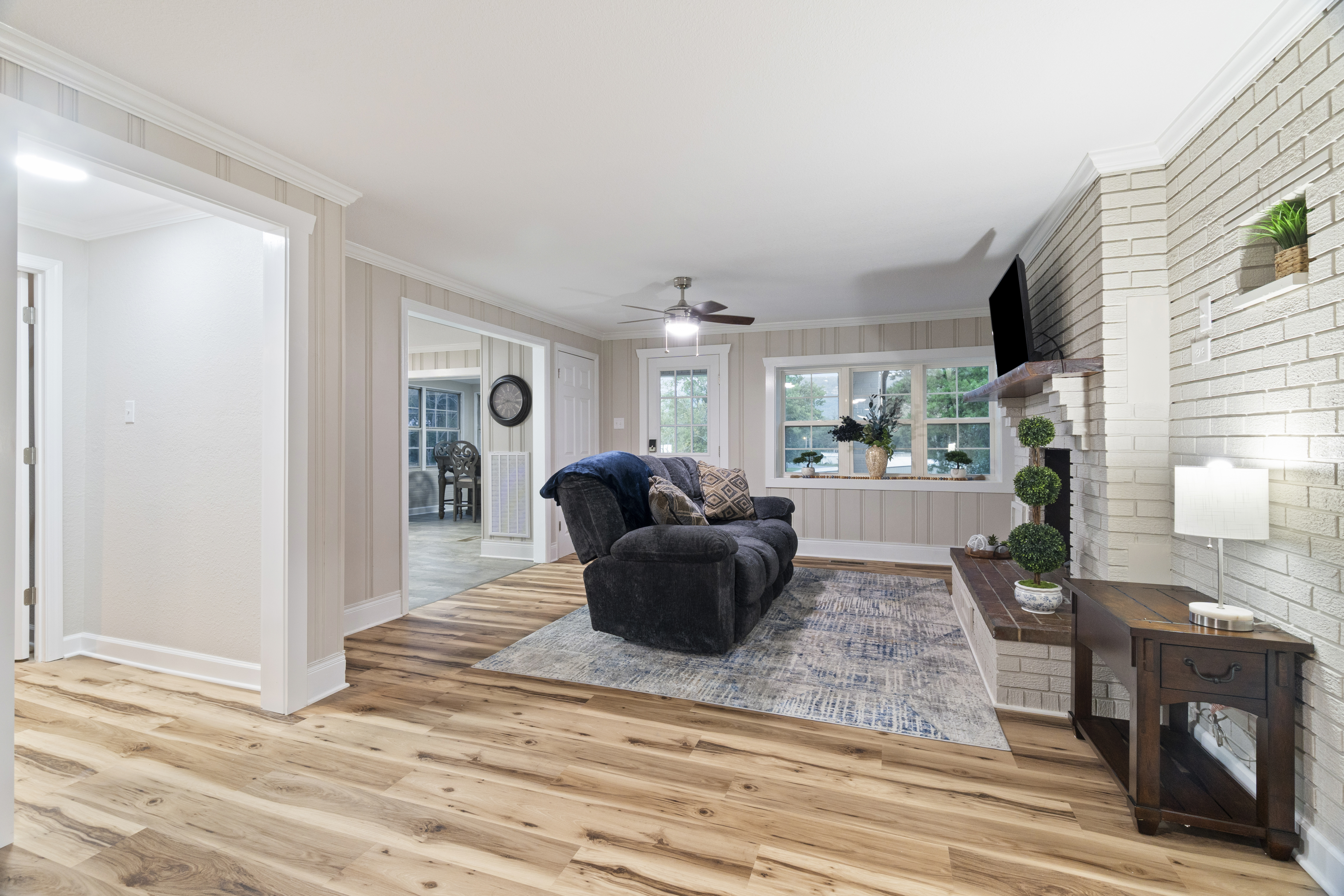 Bright, cozy living room with fireplace, TV, and spacious open layout