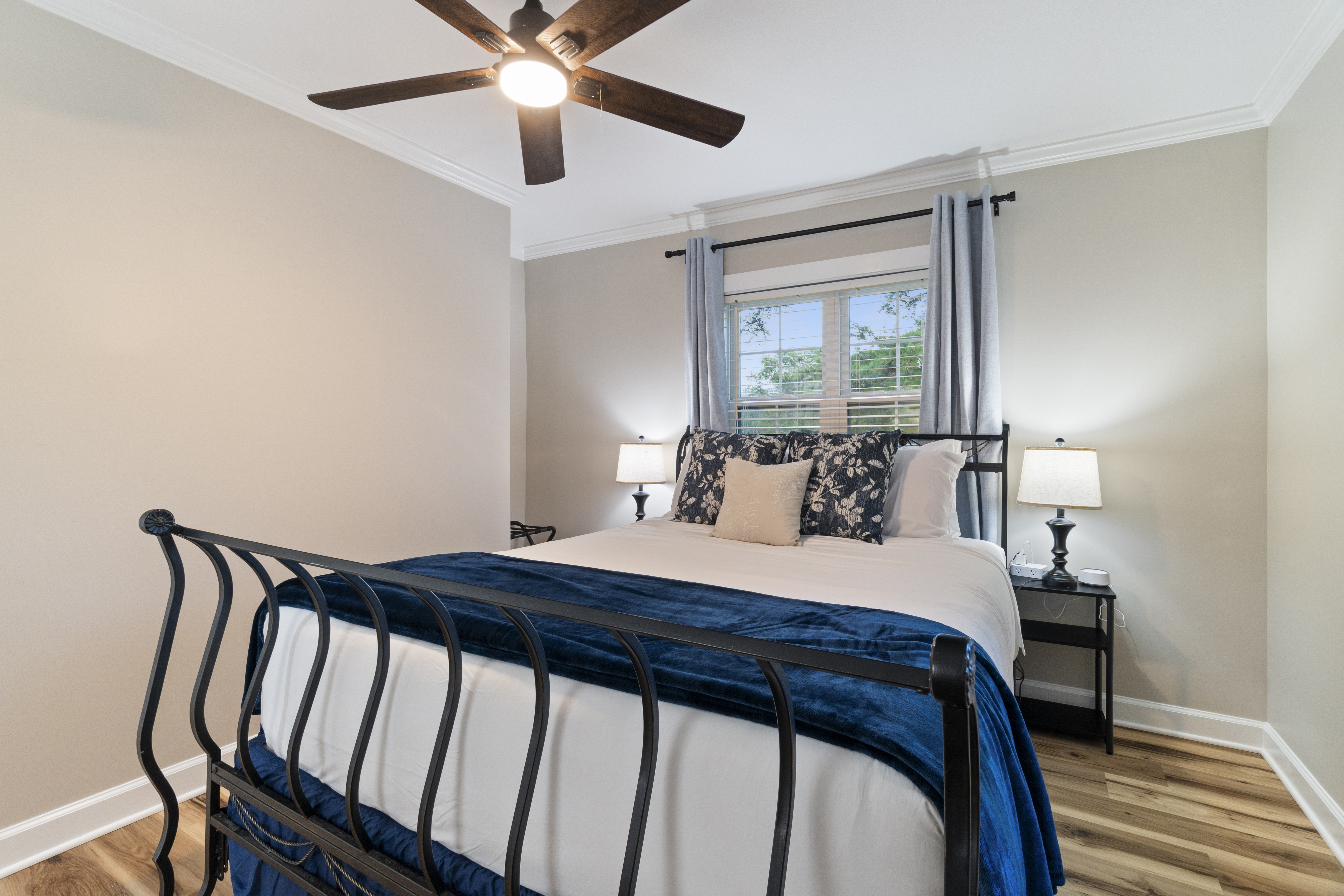 Bright, cozy bedroom with stylish blue accents and ceiling fan