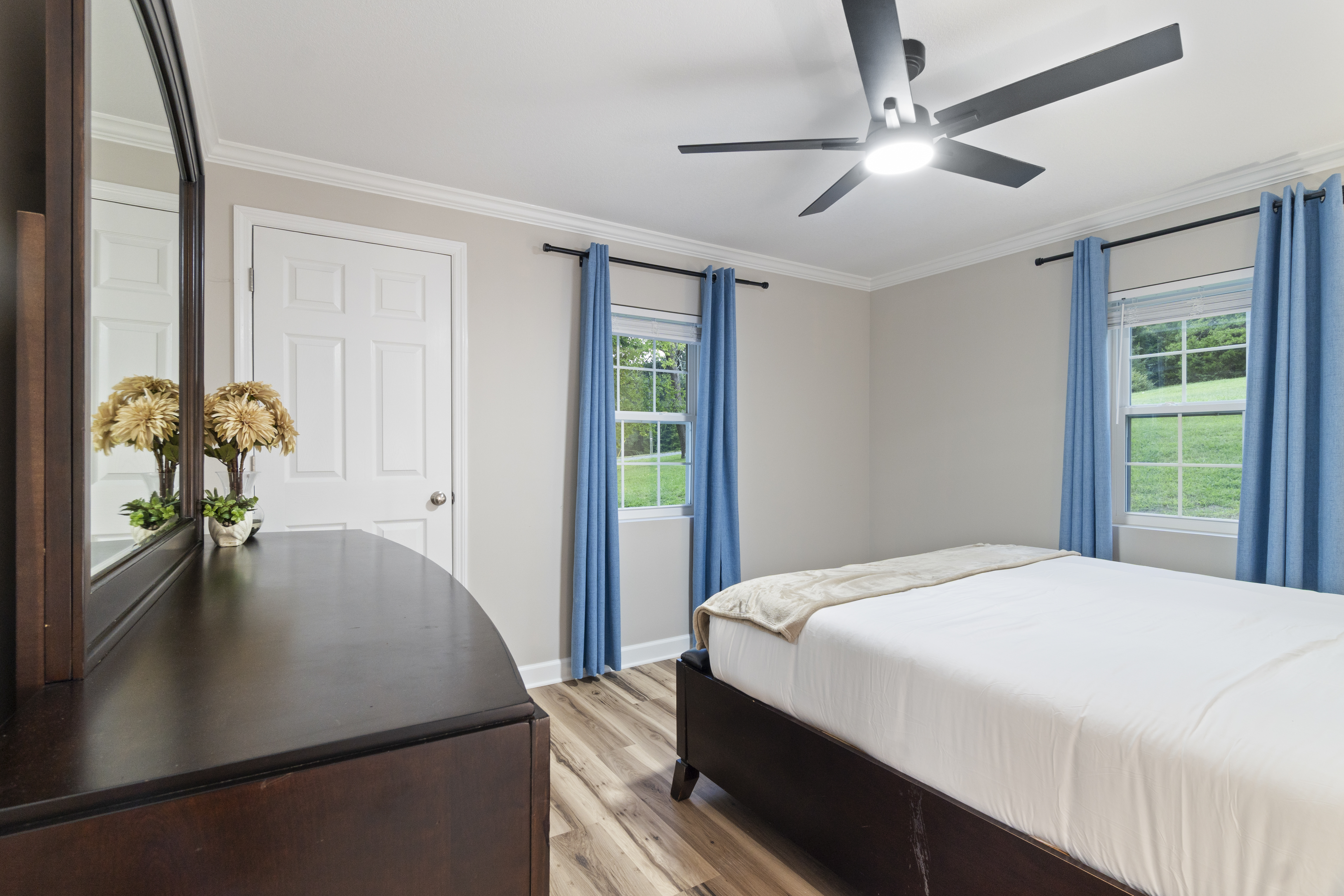 Bright, peaceful bedroom with large windows and serene outdoor views