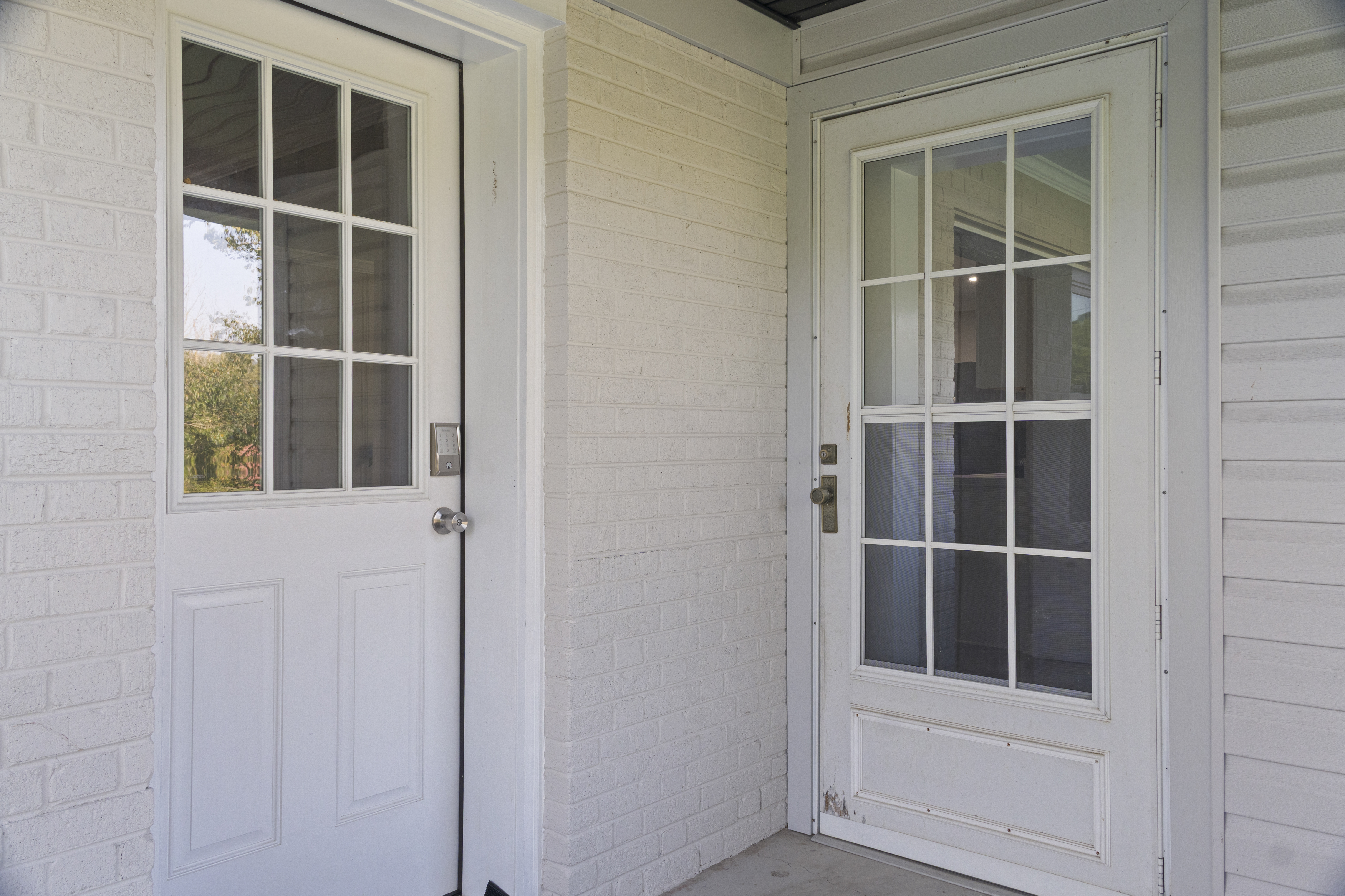 Covered entry with bright French-style doors and a clean classic look