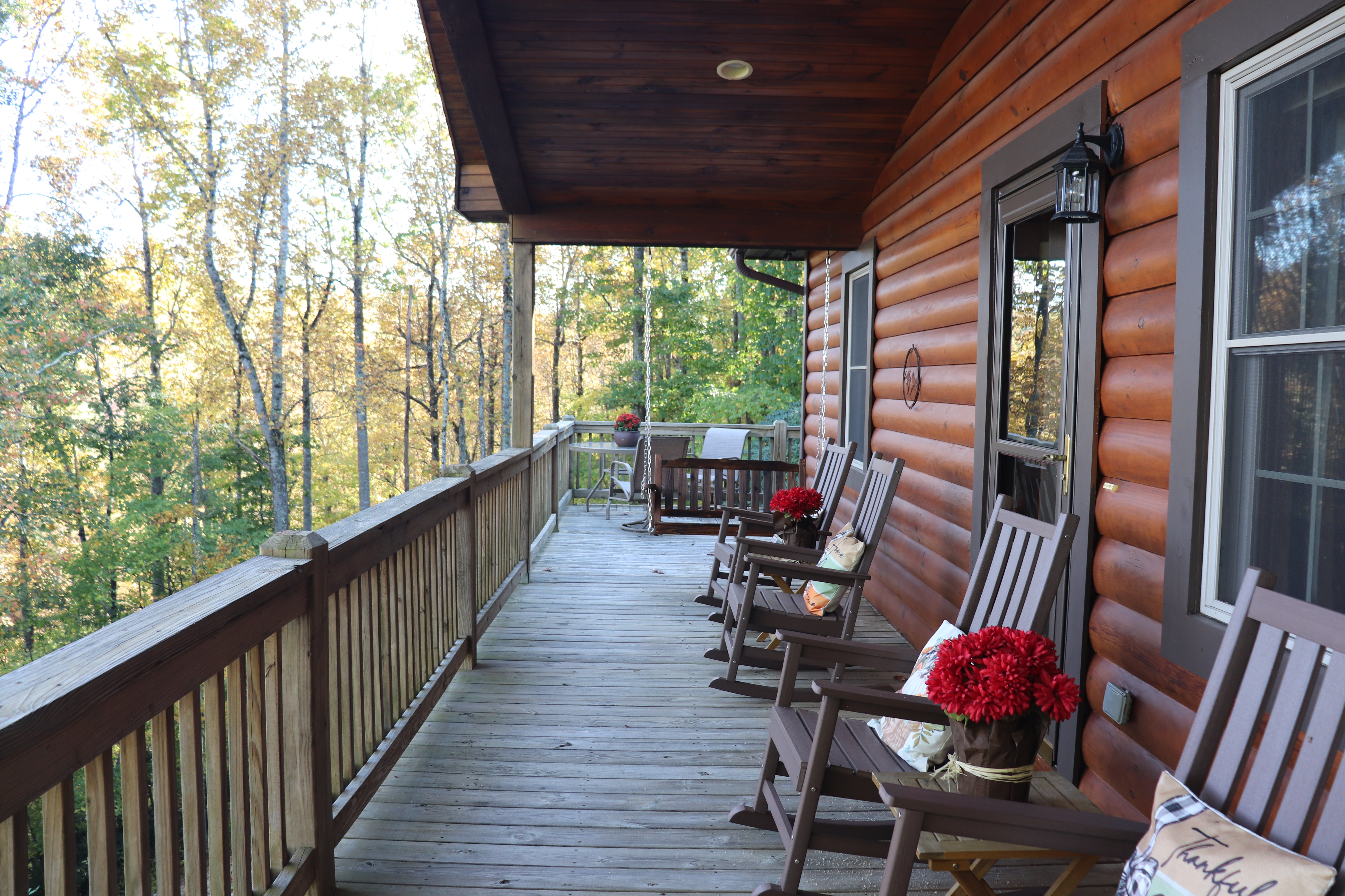 Covered cabin porch with rocking chairs and serene wooded views