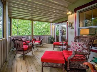 Relax on the screened porch with plush seating and peaceful wooded views