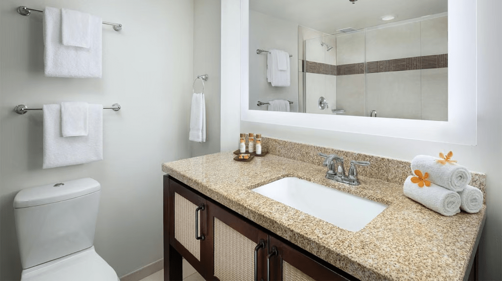 Bright spa-like bathroom with granite vanity and glass-enclosed shower