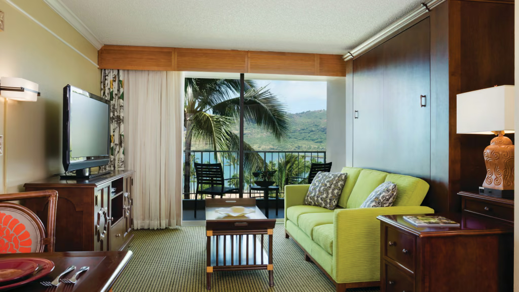 Cozy island-style suite with balcony seating and lush tropical water views