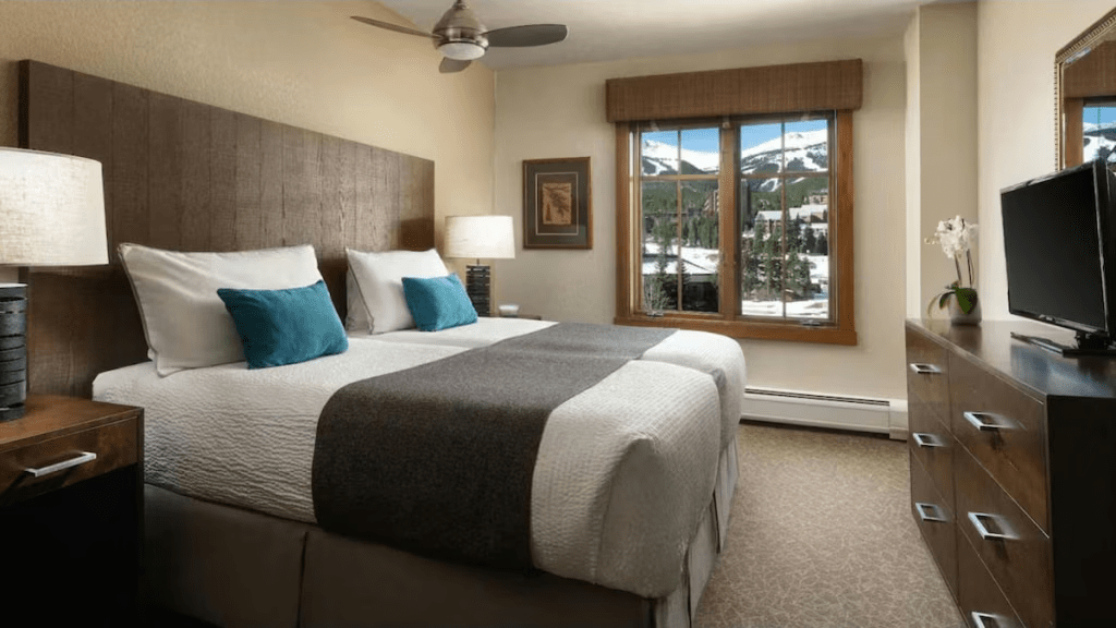 Cozy king bedroom with mountain views, warm wood accents, and TV