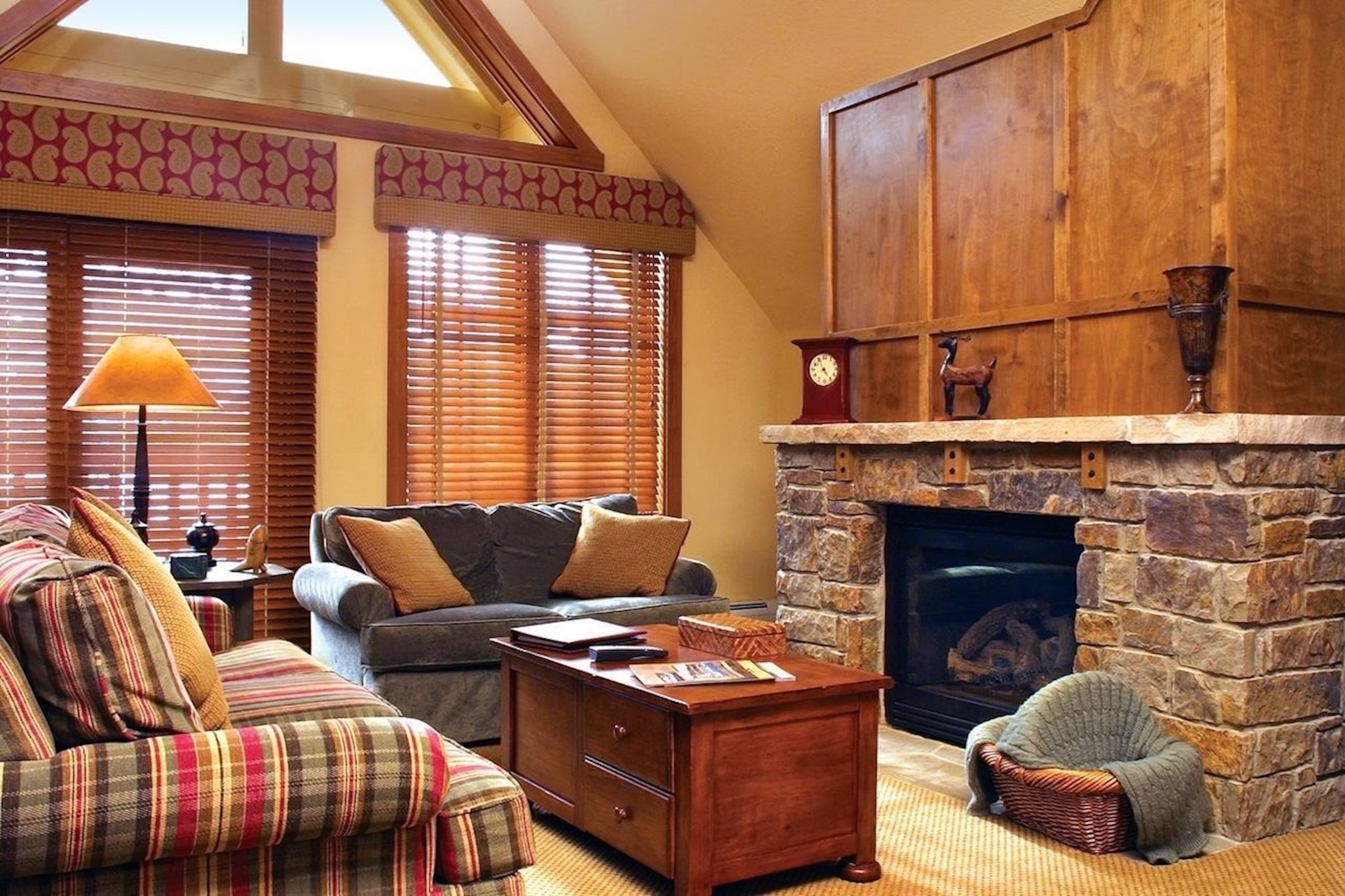 Cozy lodge-style living room with stone fireplace and abundant natural light